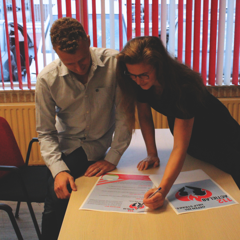 voortgezet onderwijs Twee mensen ondertekenen documenten aan een tafel en brainstormen